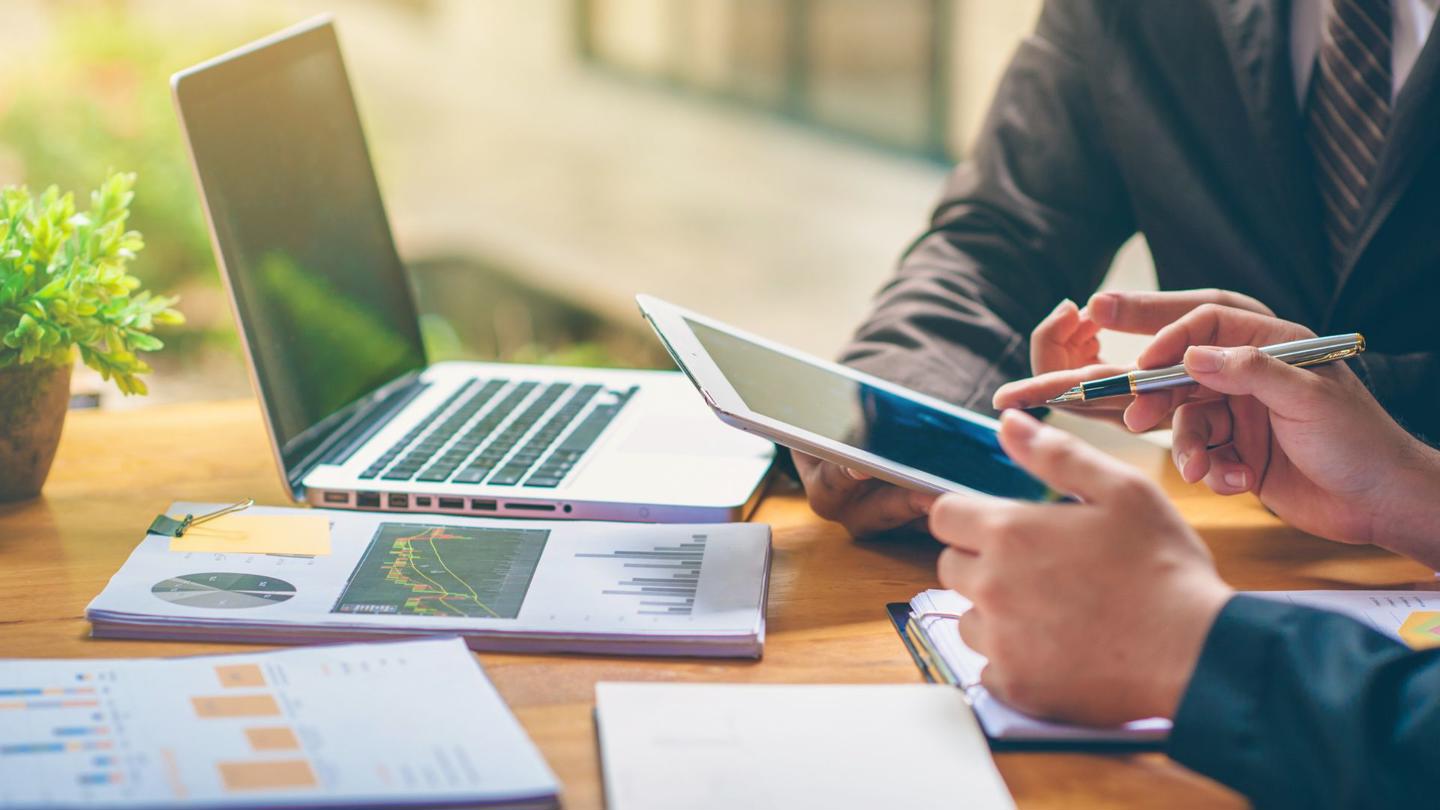 Two people studying in front of a laptop and tablet