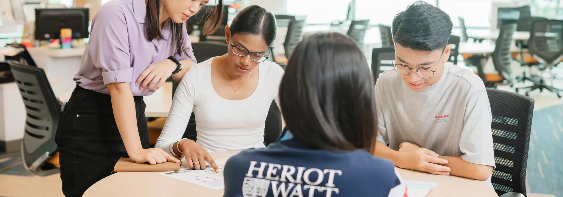 A group of students looking at the printed publication