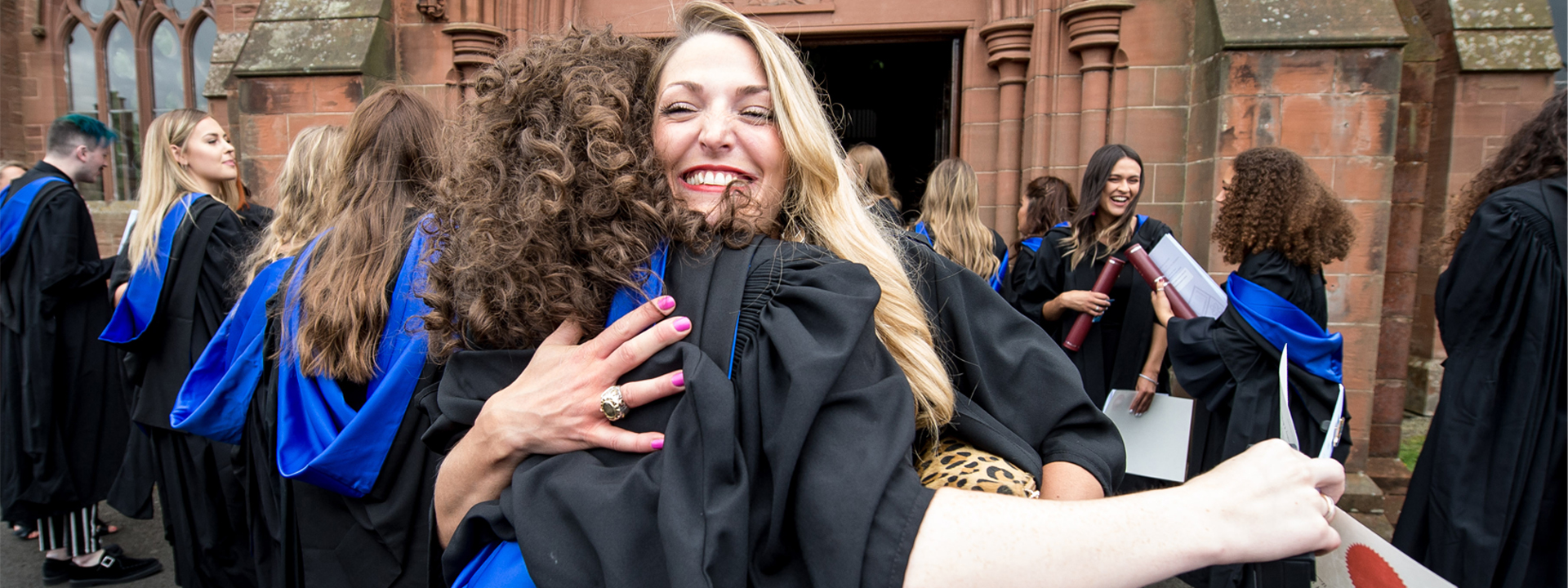 Graduates hugging at their graduation day