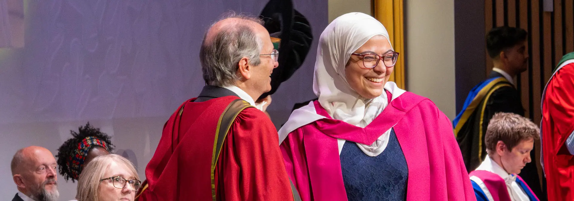 A PhD graduate receives her graduation certificate at the graduation ceremony.