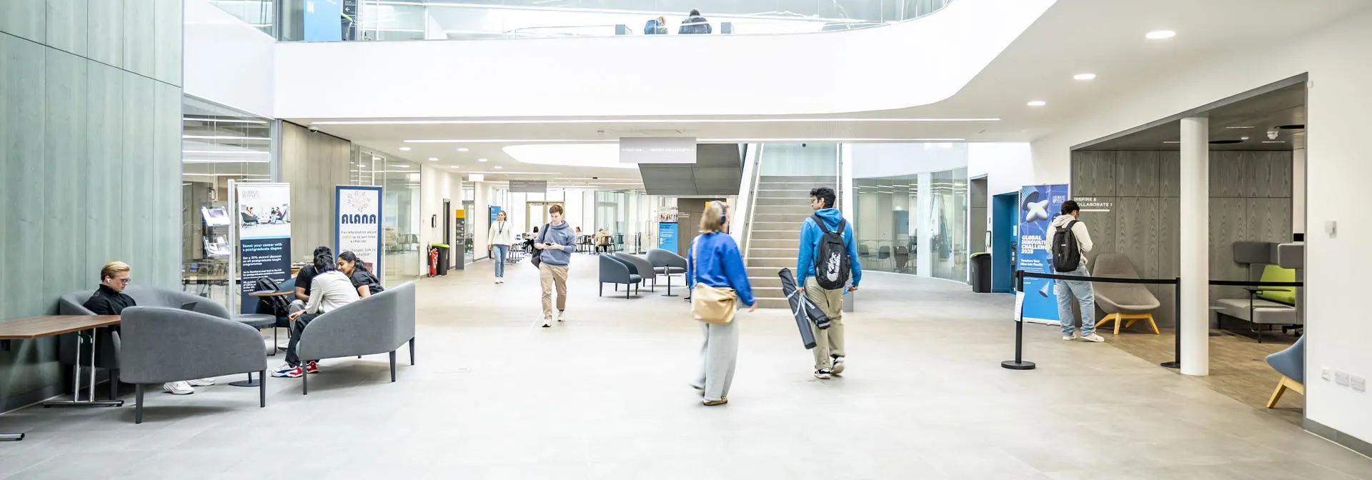 Students chat in the brightly lit GRID building foyer.