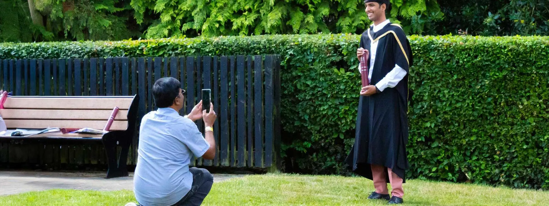 A man takes a photo of to capture a celebratory moment at a graduation ceremony.