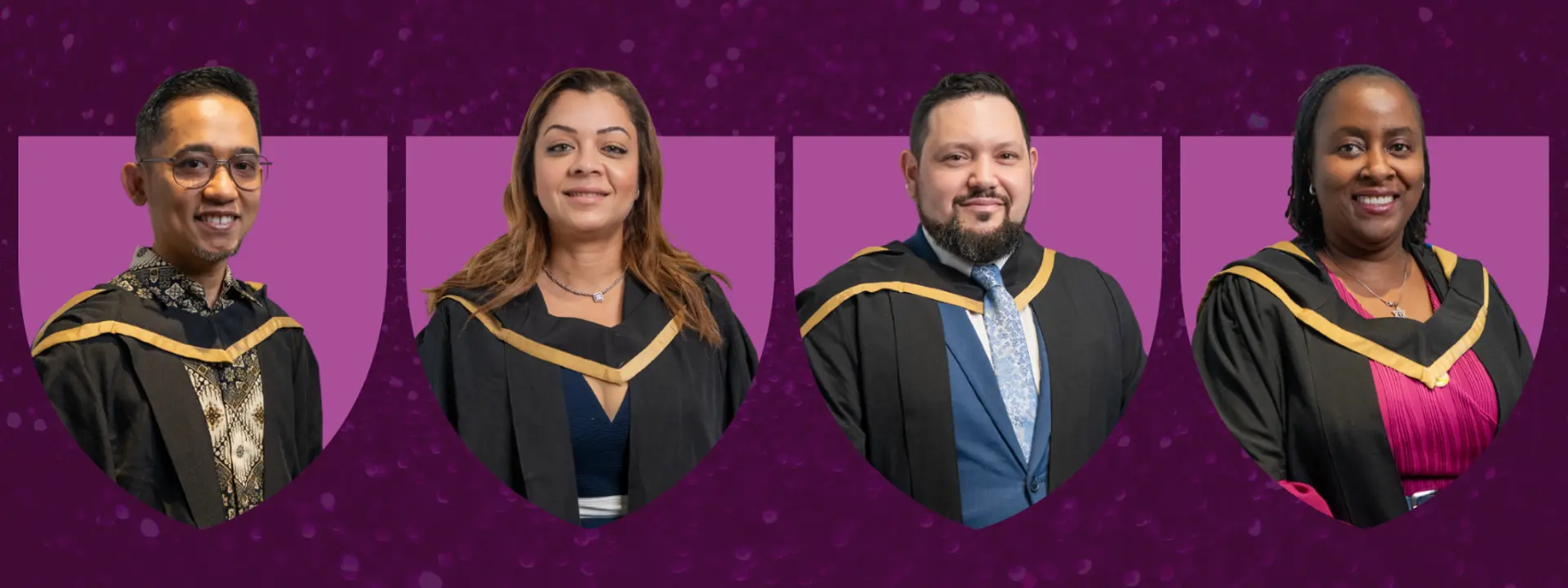 Graduates in their robes smiling at the camera.
