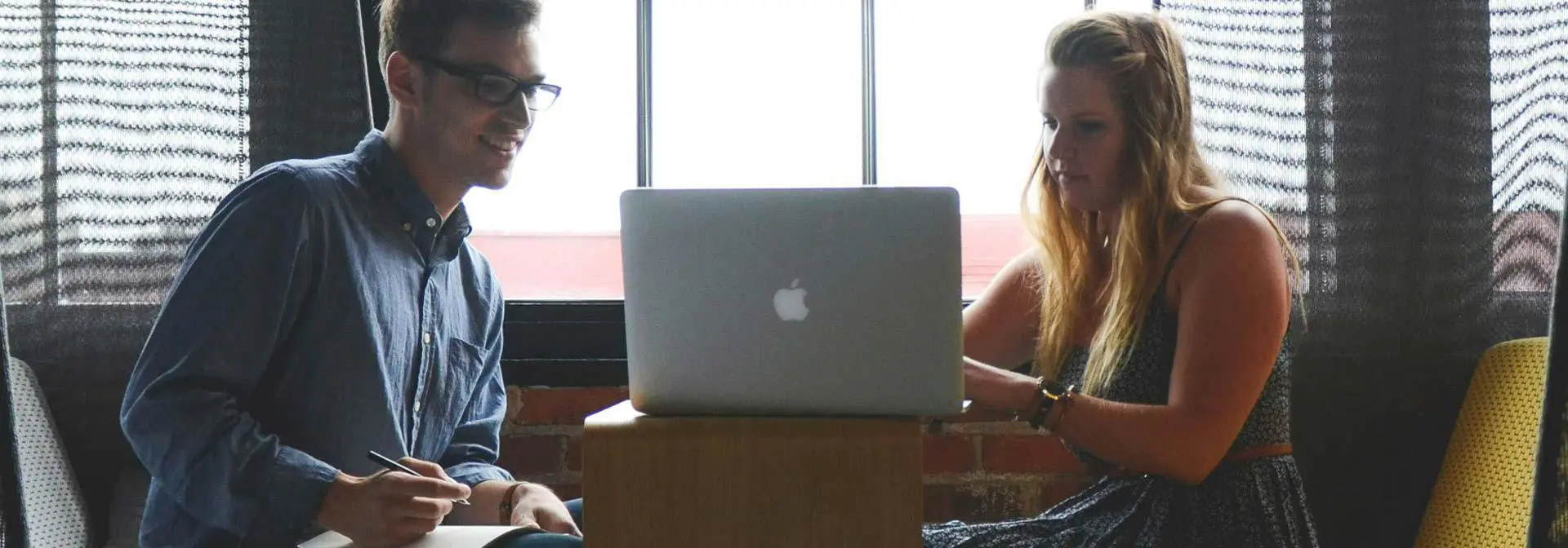 Two students work together on a laptop