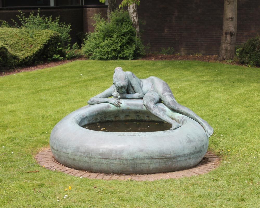 Bronze sculpture of a girl by a pool