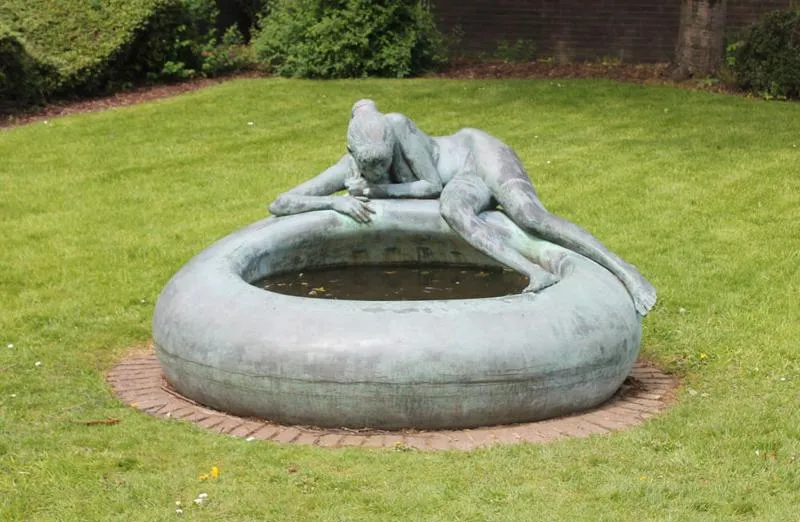 Bronze sculpture of a girl by a pool
