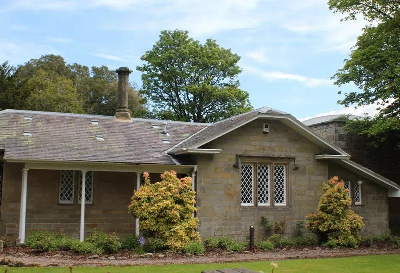 The cottage, along with its wall and railings, are listed structures Stone cottage