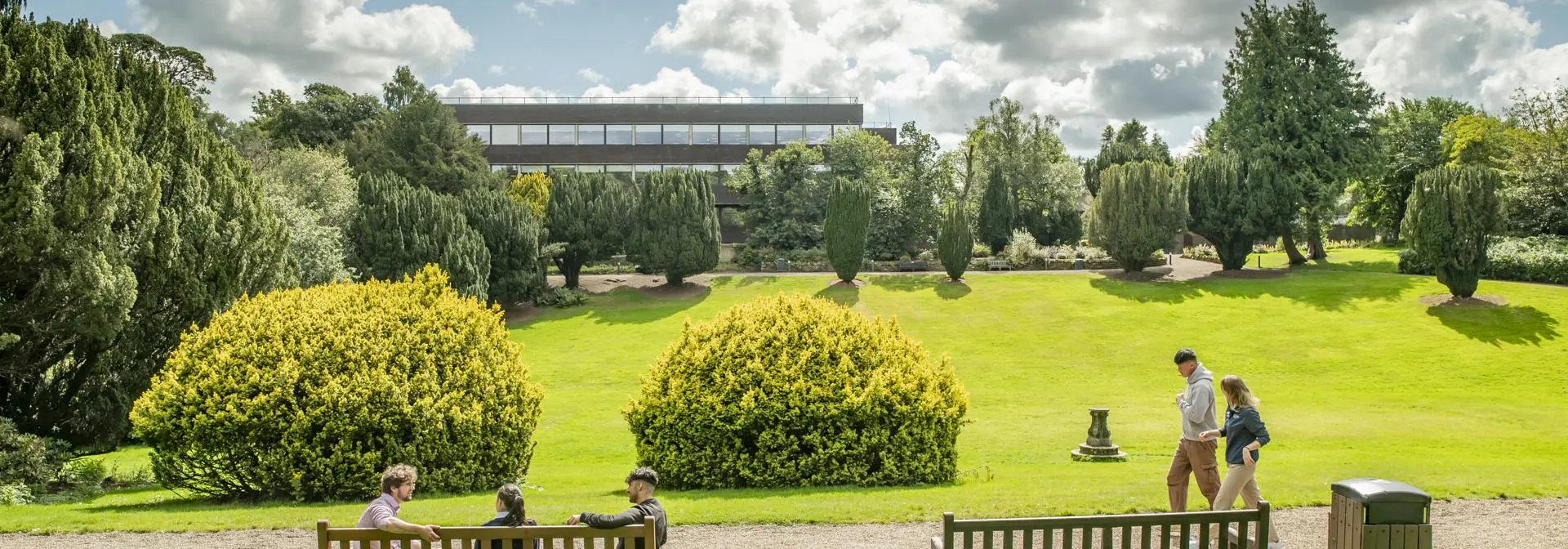 Students seated and walking across the Sunken Garden at the Edinburgh Campus