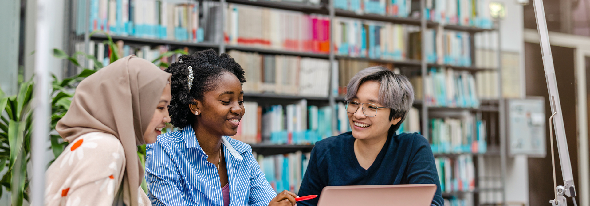 Three students working together in a library
