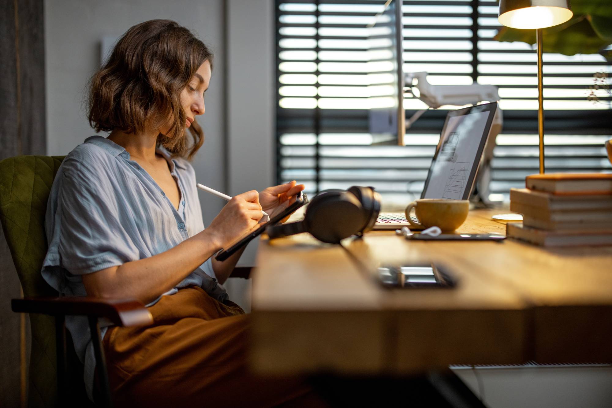 A woman writes on a drawing pad at a desk in an office