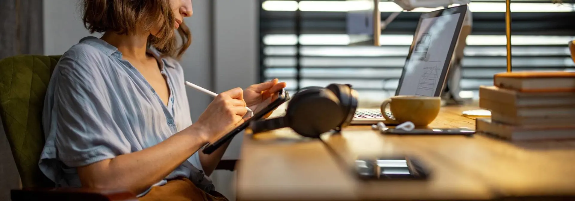 A woman writes on a drawing pad at a desk in an office