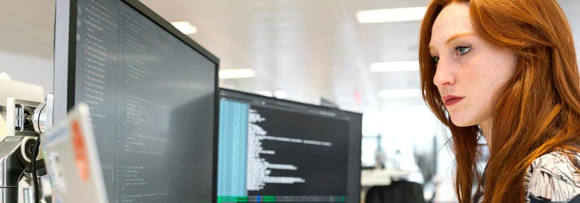 A woman working on a computer looks intently at the screen.