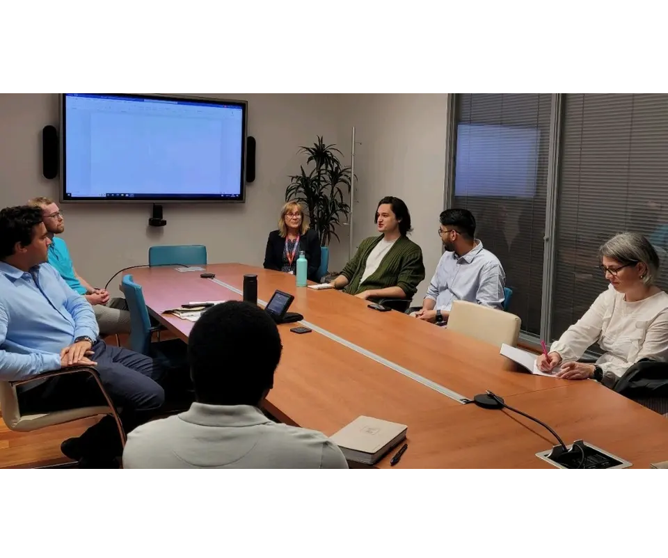 Meeting room full of people in deep discussion.