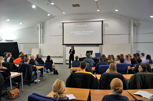 Multiple individuals sitting and listening to a presentation.