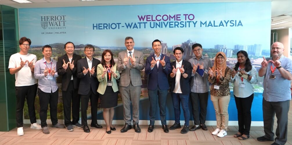 Heriot-Watt University Malaysia employees holding up fingers to make a letter 'W'