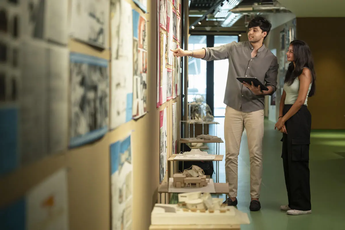 Two individuals looking at a wall of information