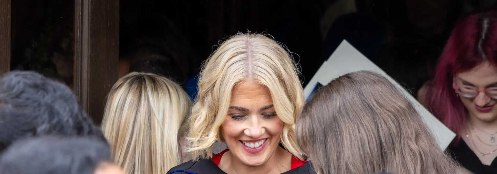 Two graduates holding their graduation scrolls