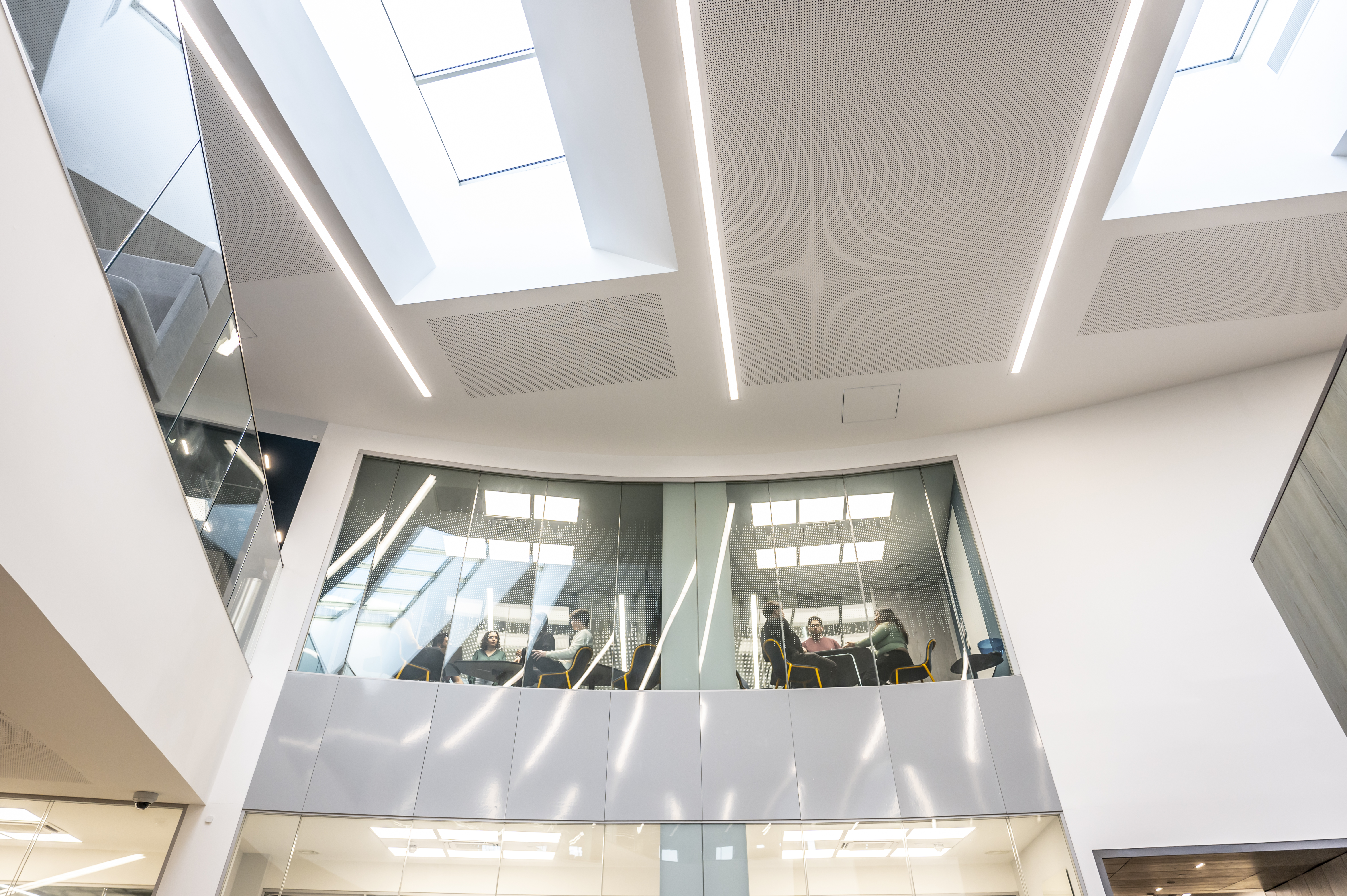Shot of the inside of the Heriot-Watt GRID building, with a view up from below to glass windowed meeting rooms
