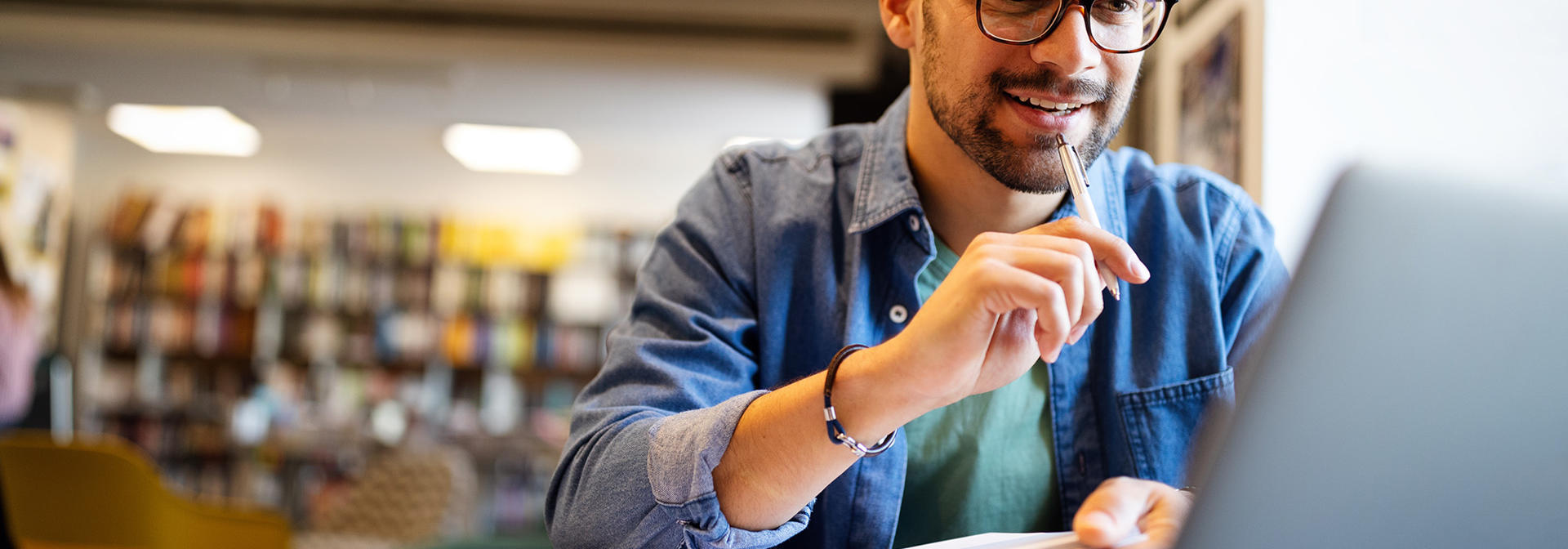 Man working on a laptop in a library.