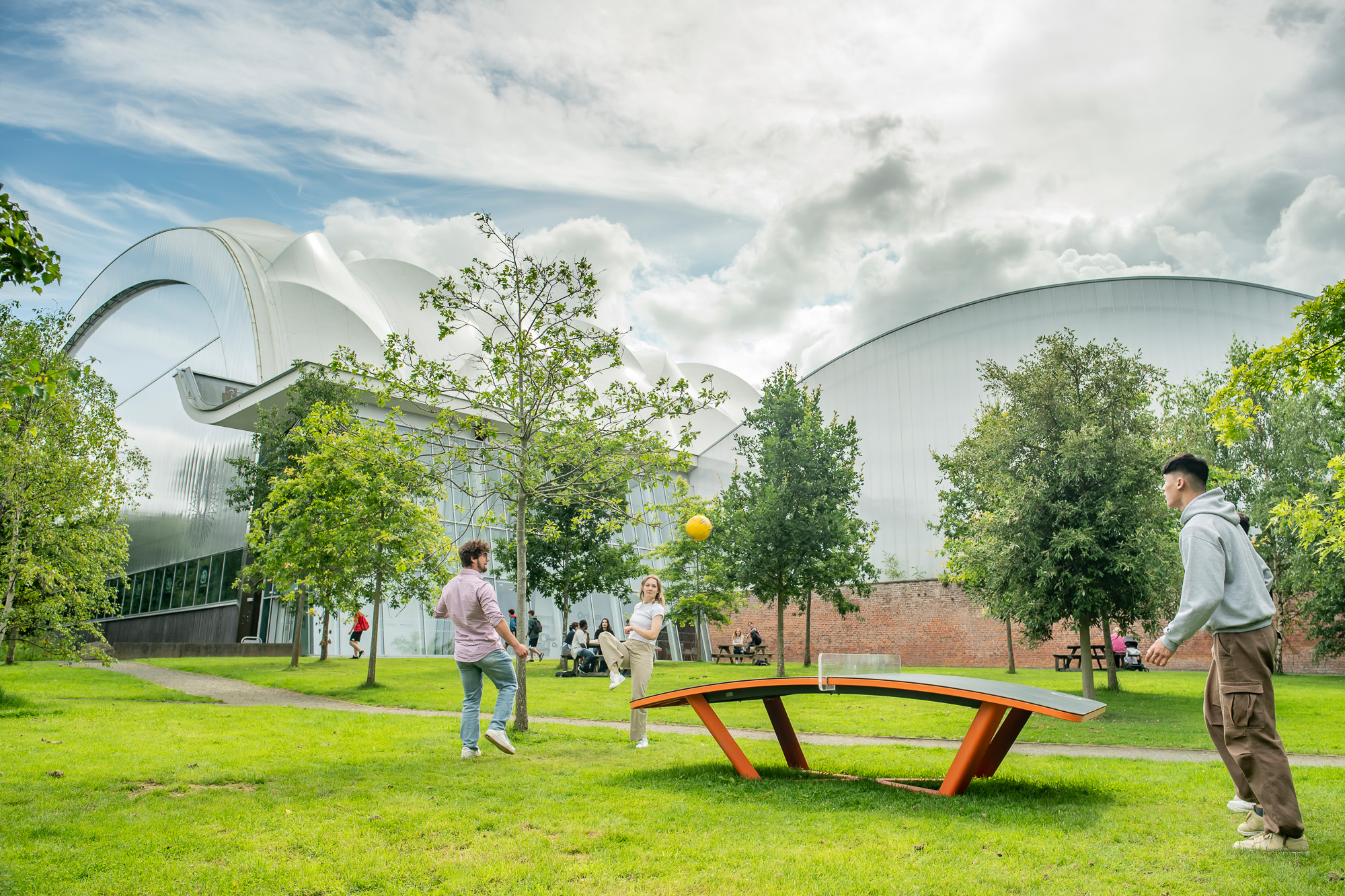 Students playing with a ball on the teqball table outside Oriam.