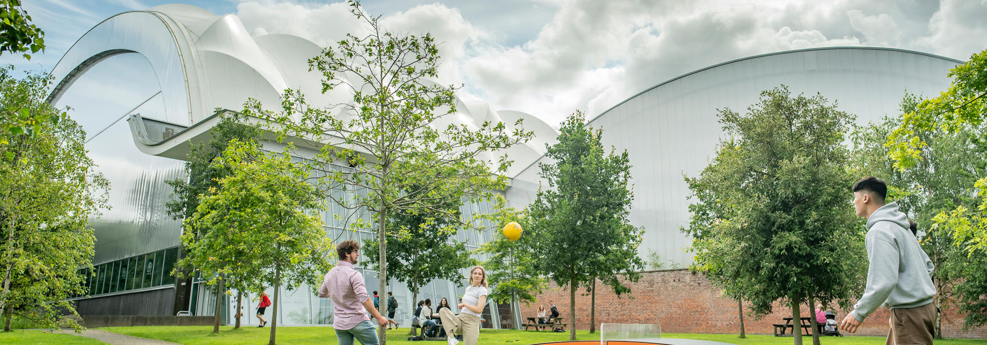 Students playing with a ball on the teqball table outside Oriam.