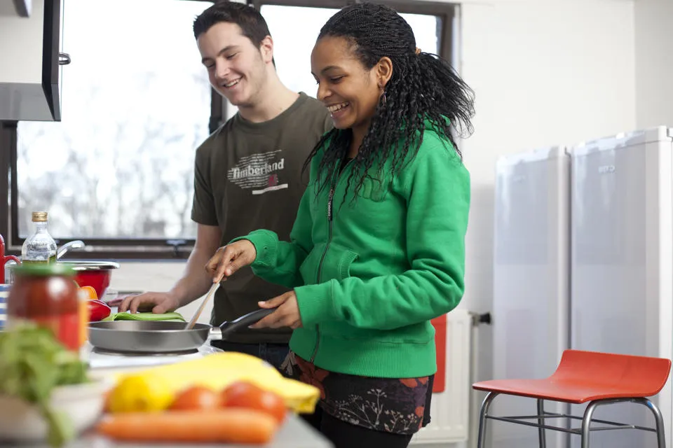 Two students cook in a shared kitchen
