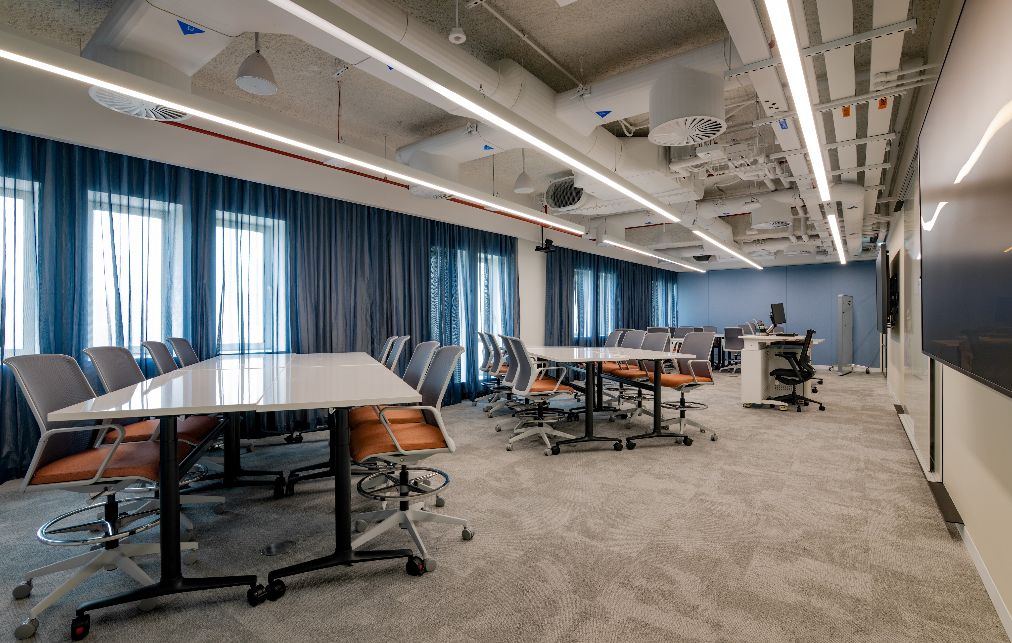 classroom with orange seats and grouped tables.