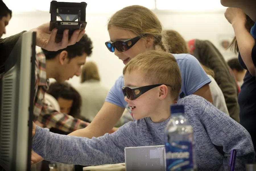 Children with protective glasss looking at lasers
