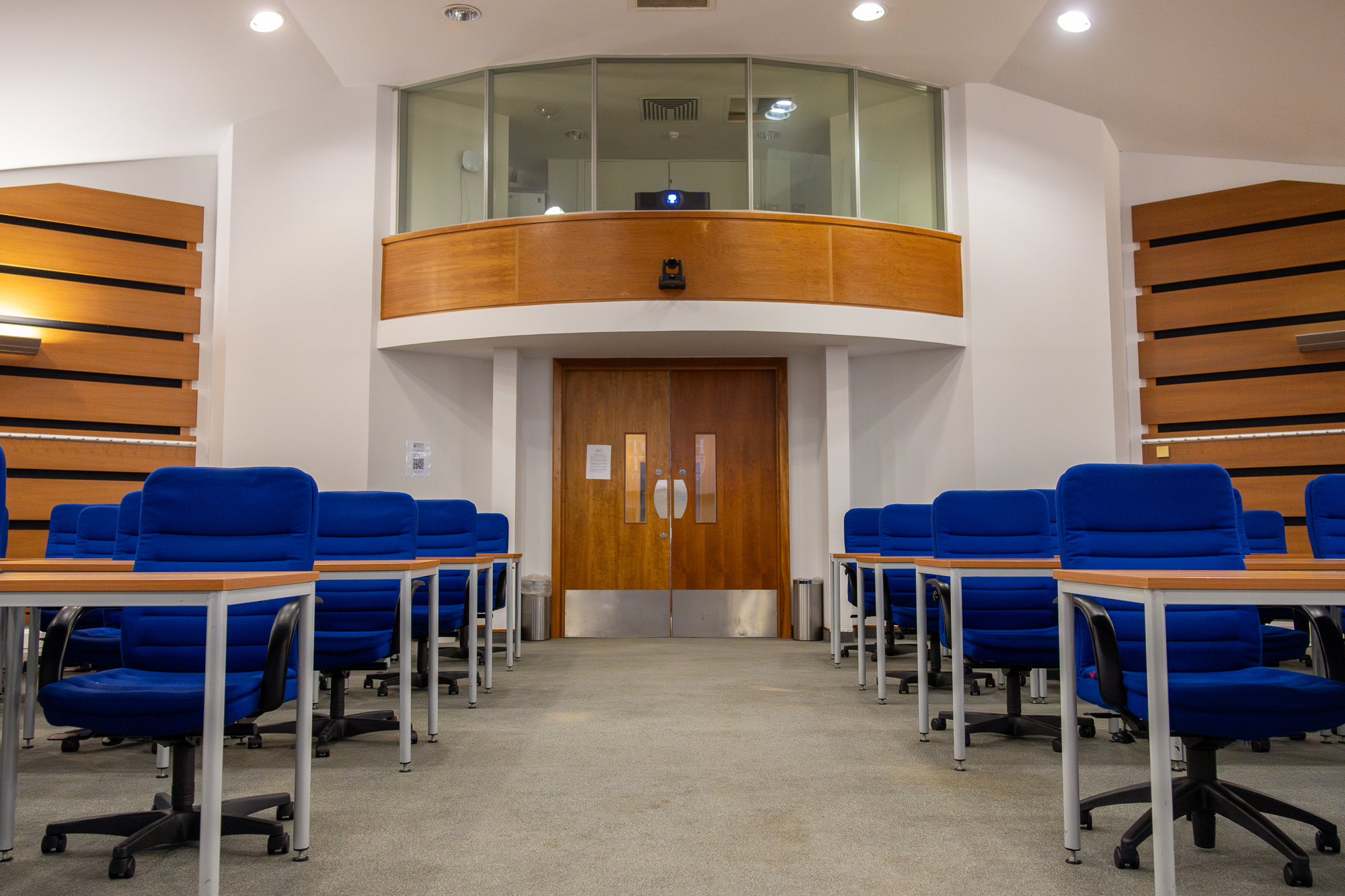 An empty room full of blue chair and desks set up for an assessment.