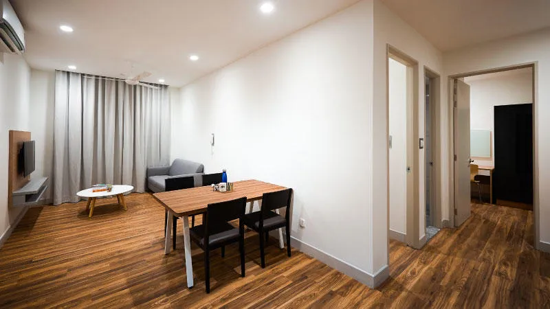 LIving hall showing wooden floor, table and chairs, couch and television