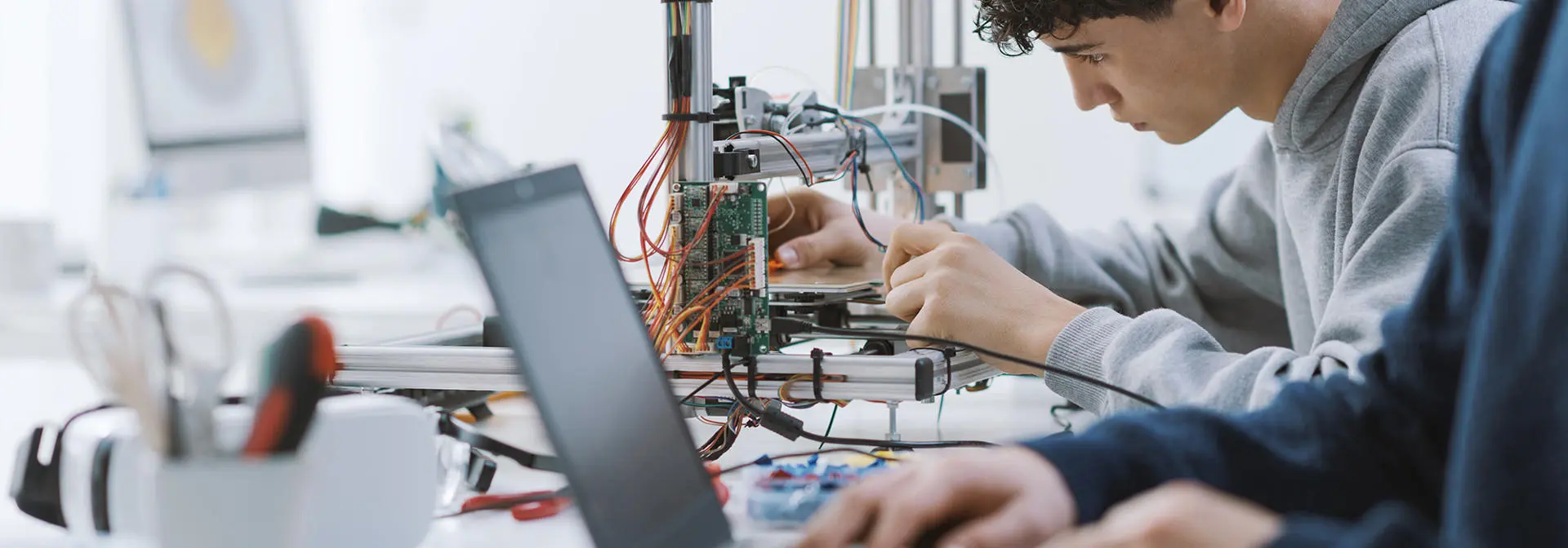 Two individuals working with cables and computer science programmes