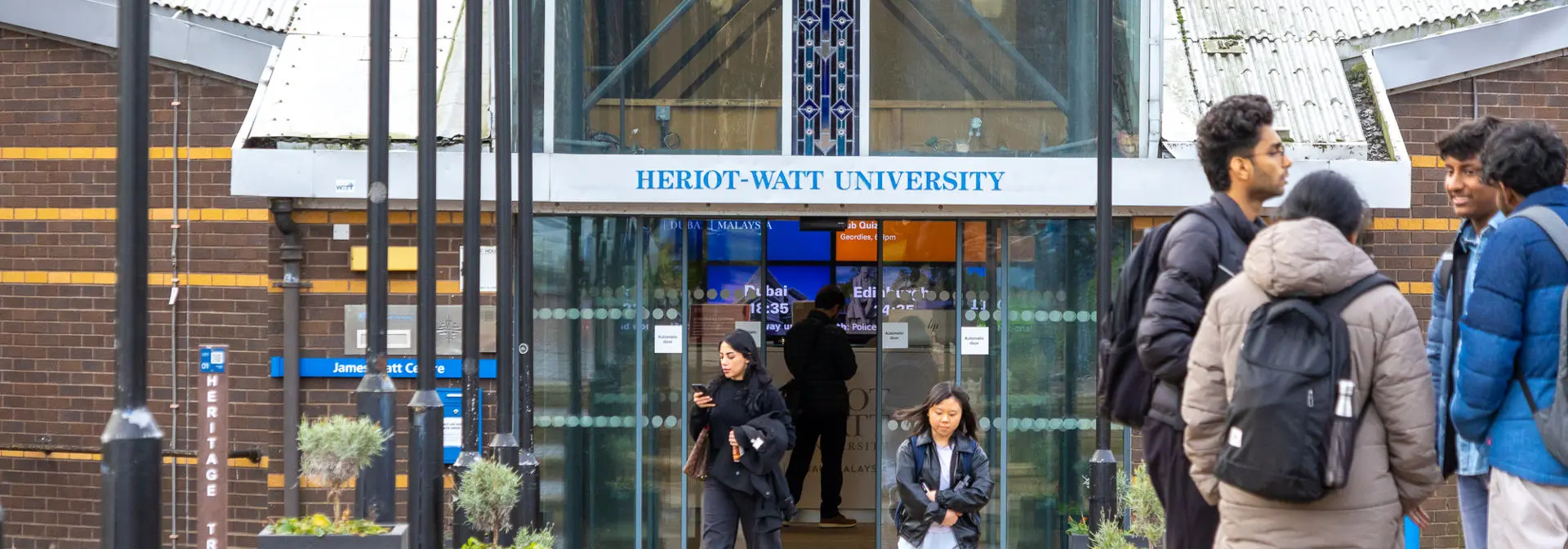 Individuals standing at an entrance to a building.