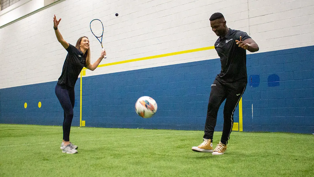 Sports coaches with racket and football at our Oriam facility