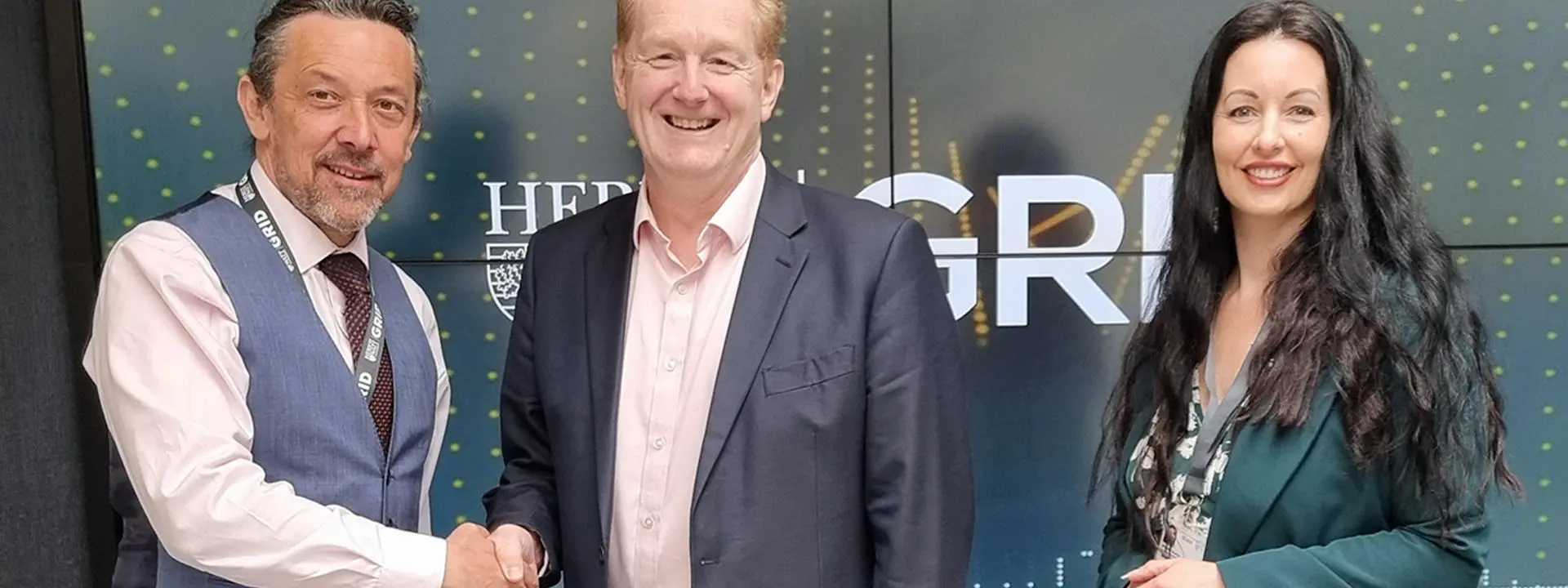 Three people stand in the Heriot-Watt GRID building agreeing on an Memorandum of Understanding