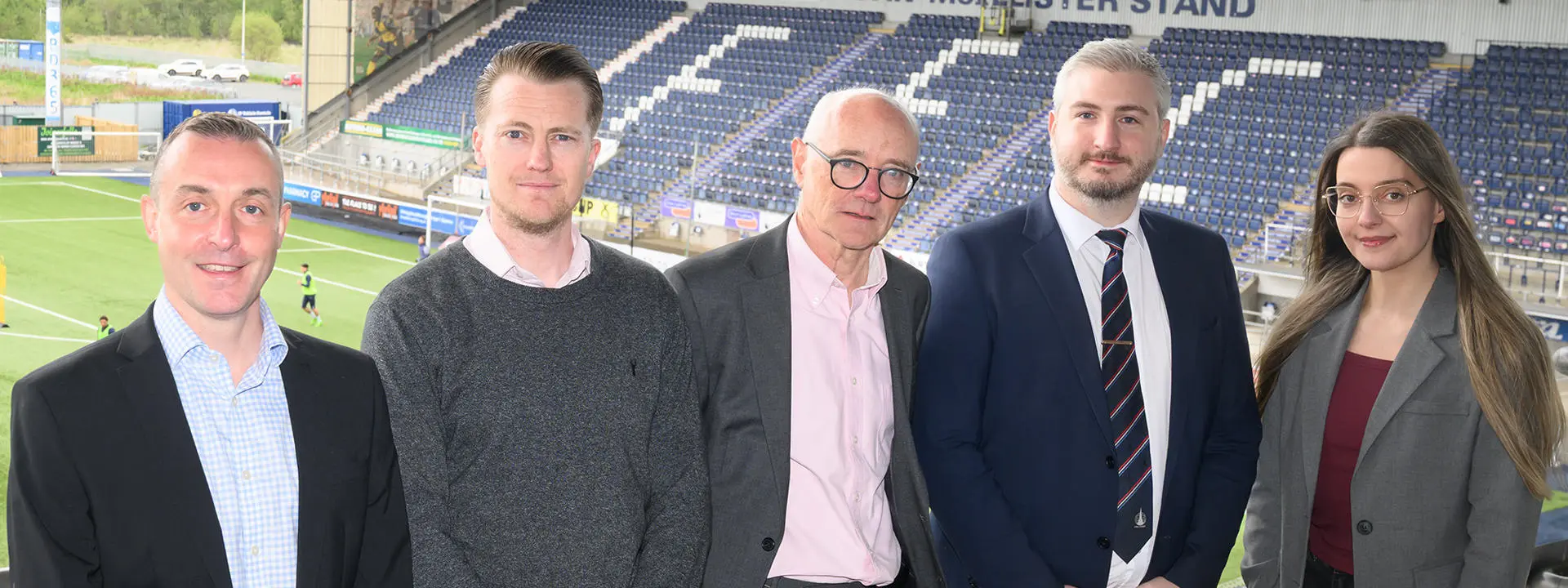 Heriot-Watt University professors and Falkirk Football Club key leaders standing at the stadium.
