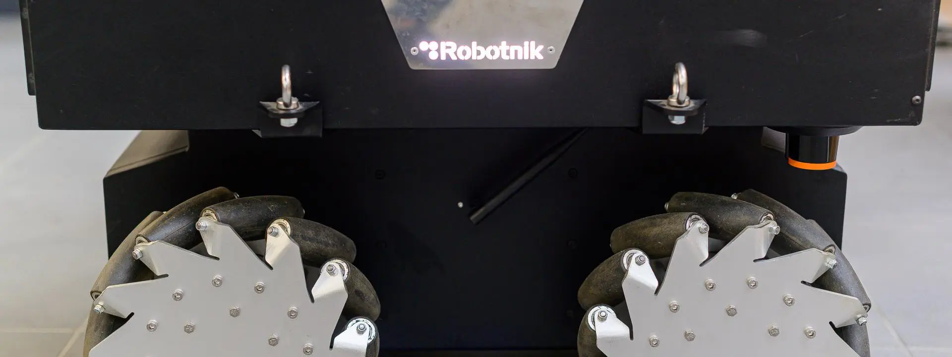 This image shows a close-up view of a Robotnik-brand robotic platform with mecanum wheels.
