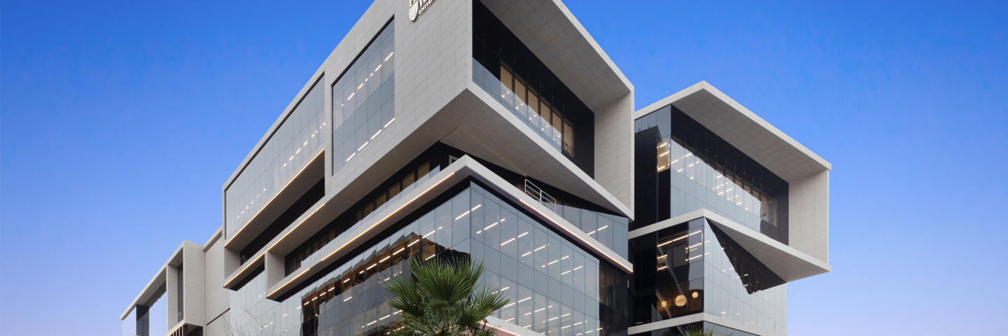 The Dubai Campus building exterior at twilight.