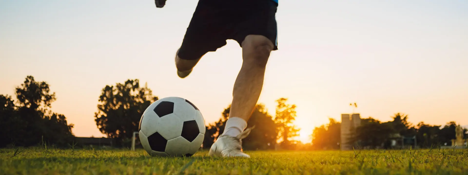 Silhouette action sport outdoors of a group of kids having fun playing soccer football