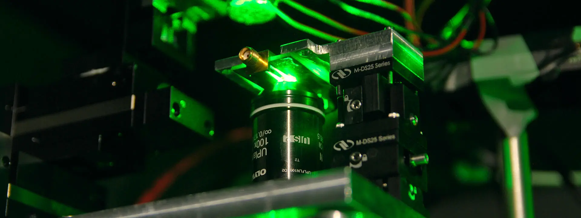 Close-up of equipment in Quantum laboratory at Heriot-Watt University with parts of the equipment showing a green light