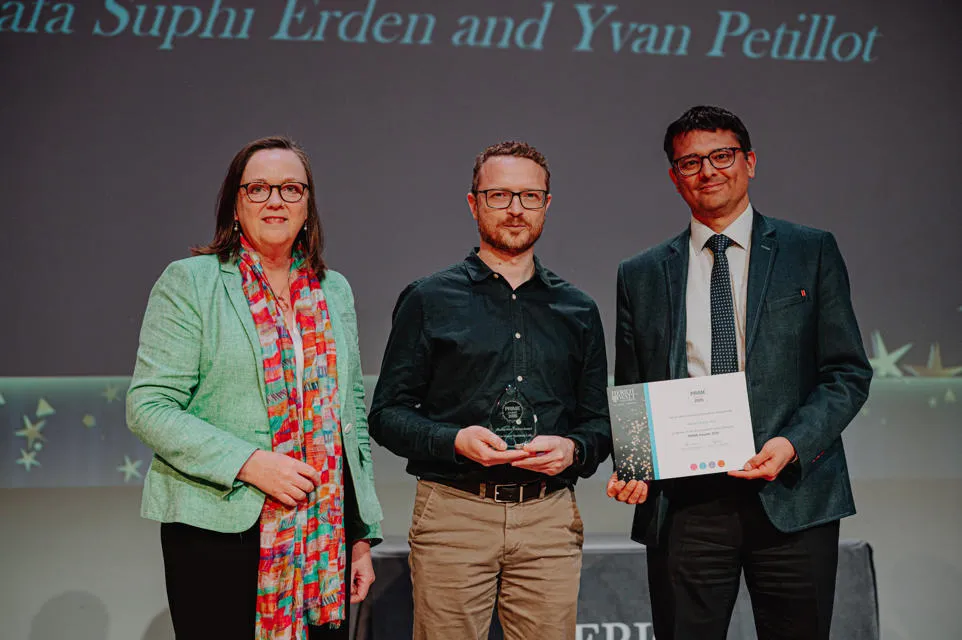 Two people receiving an award from the vice principal 