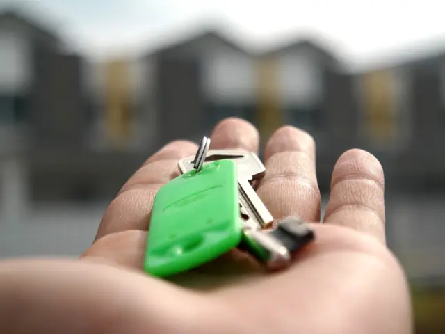 Hand holding a set of keys with green tag