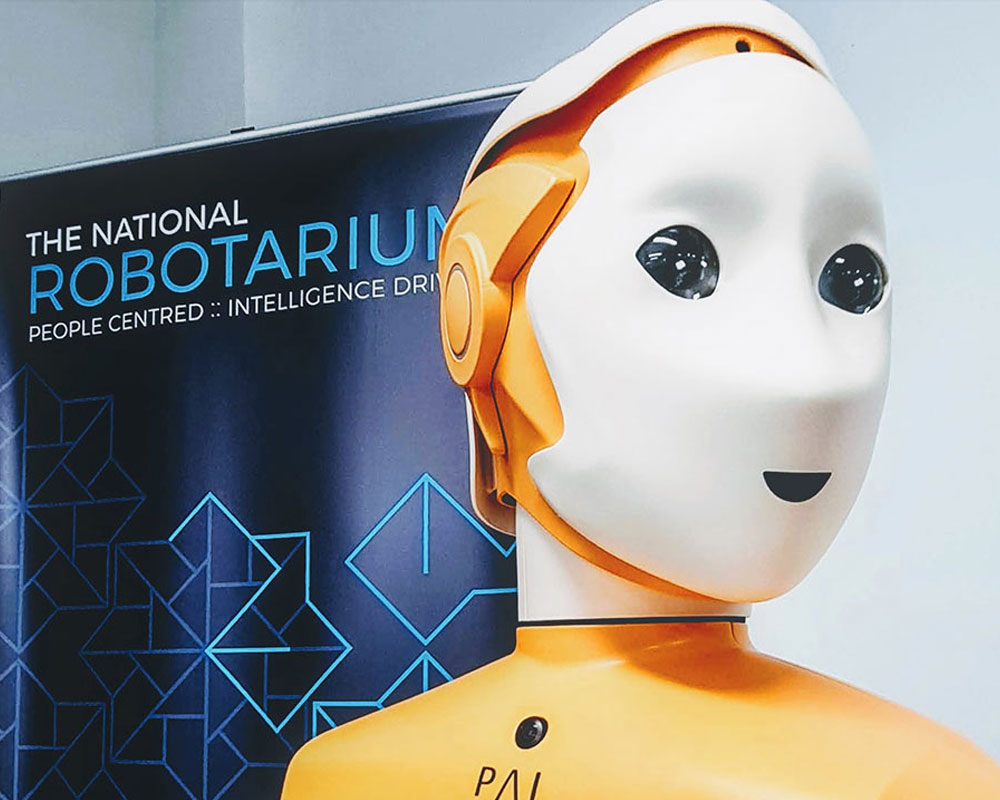 A robot beside a banner for the National Robotarium