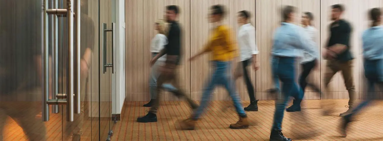 A group of people walking in an office building