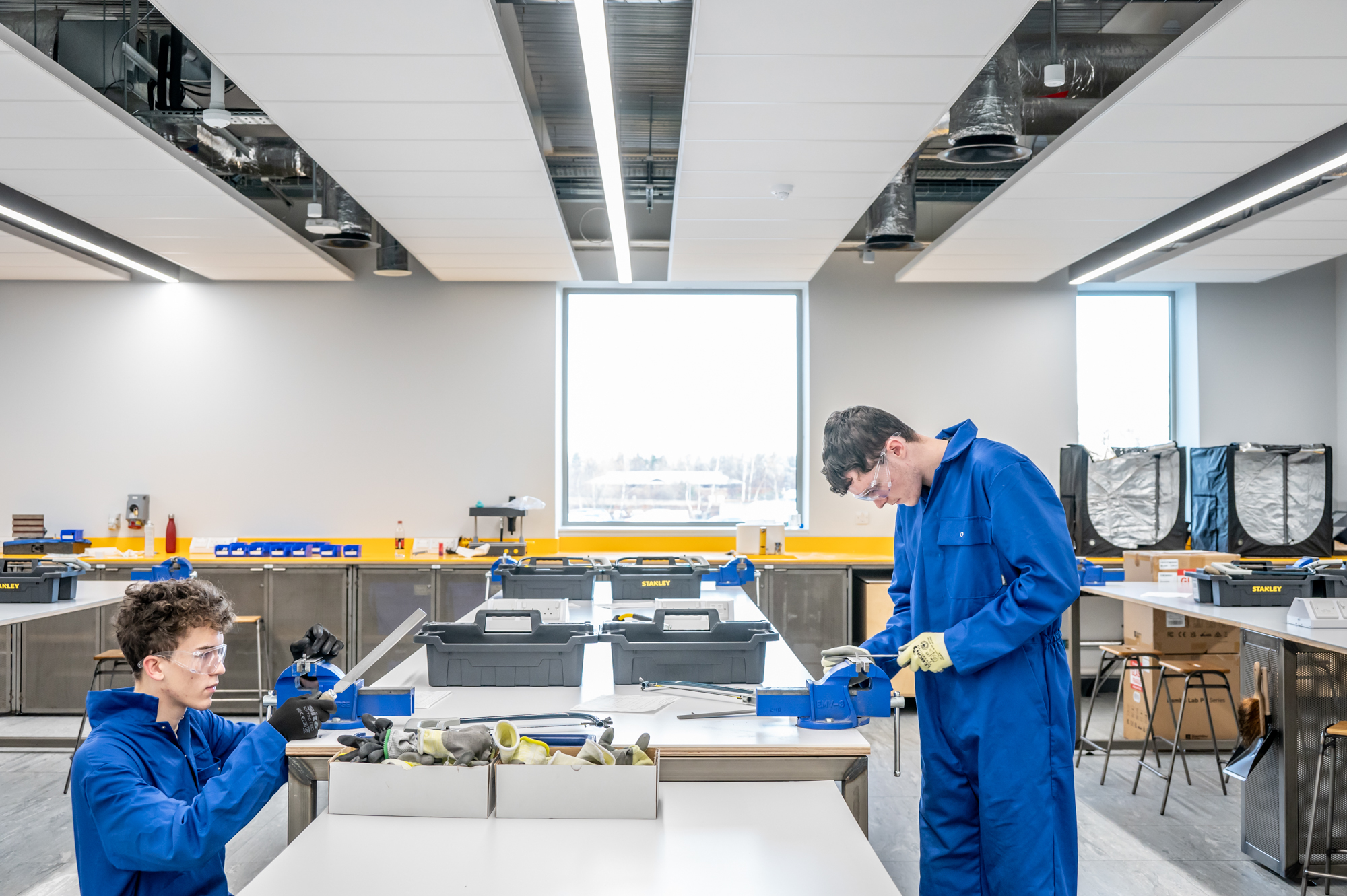 Two students using a lathe in GRID