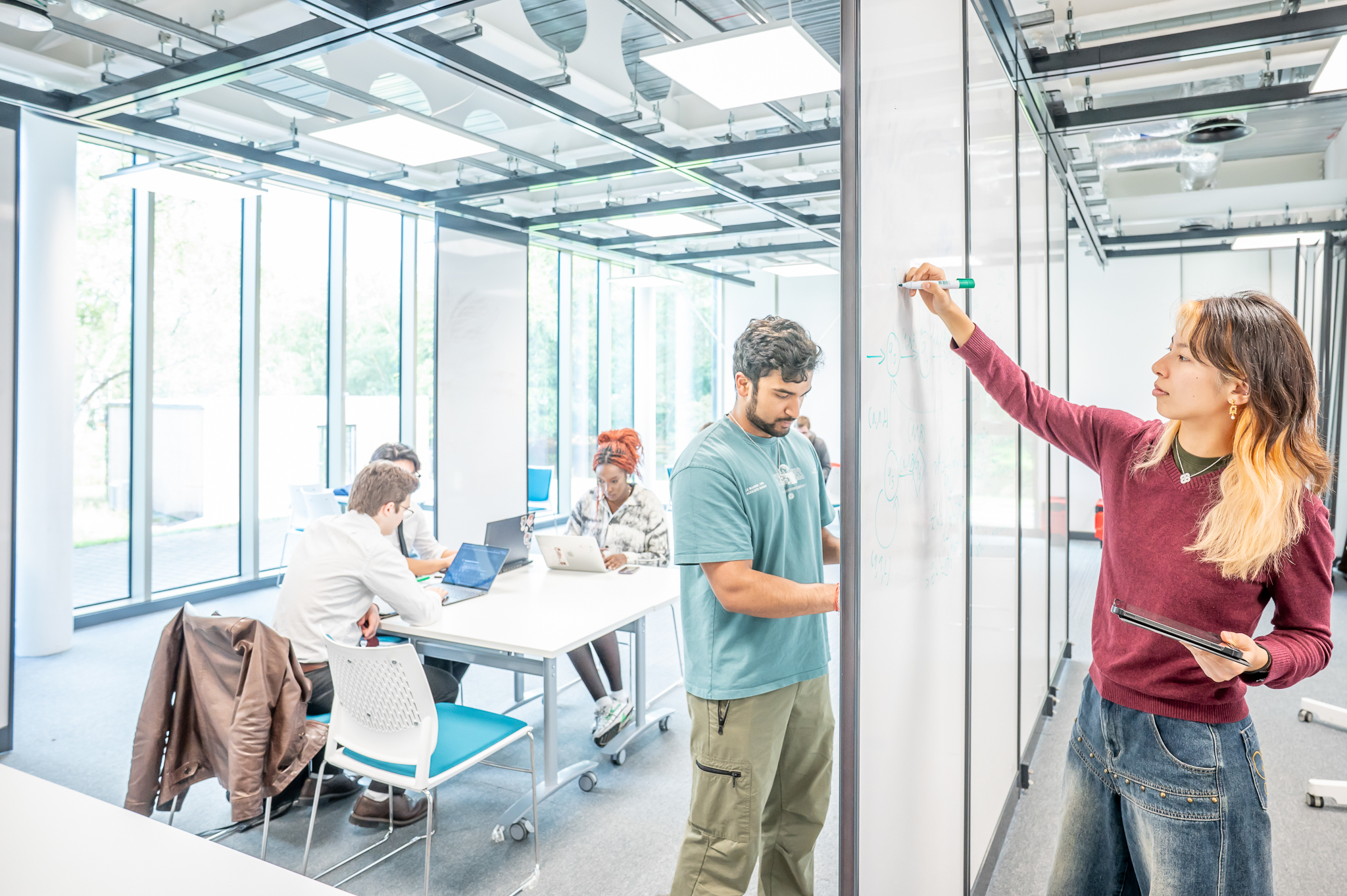 Students working on a whiteboard in a maths gym