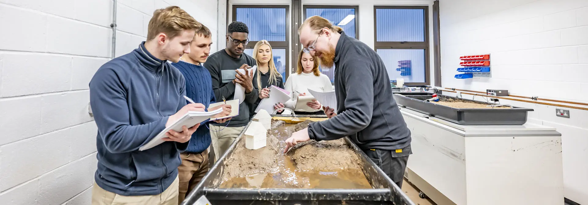Students in a geography teaching lab getting a demonstration by a lecturer