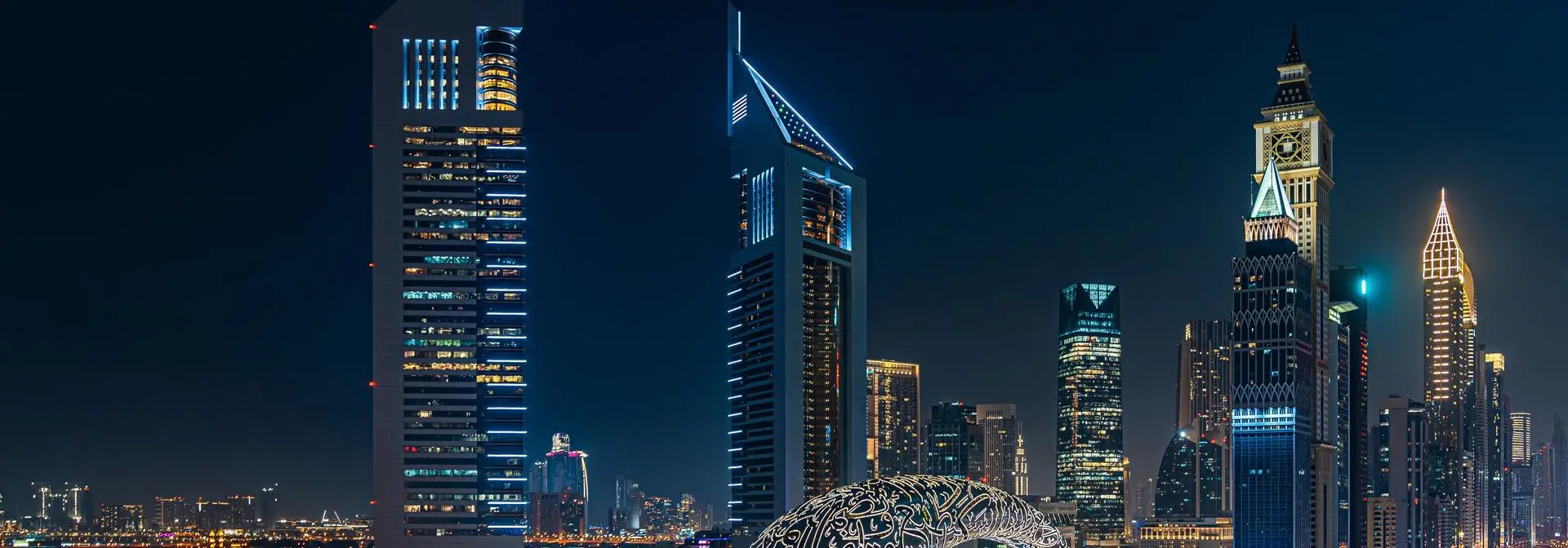 Nighttime view of Dubai with the Museum of the Future and surrounding skyscrapers