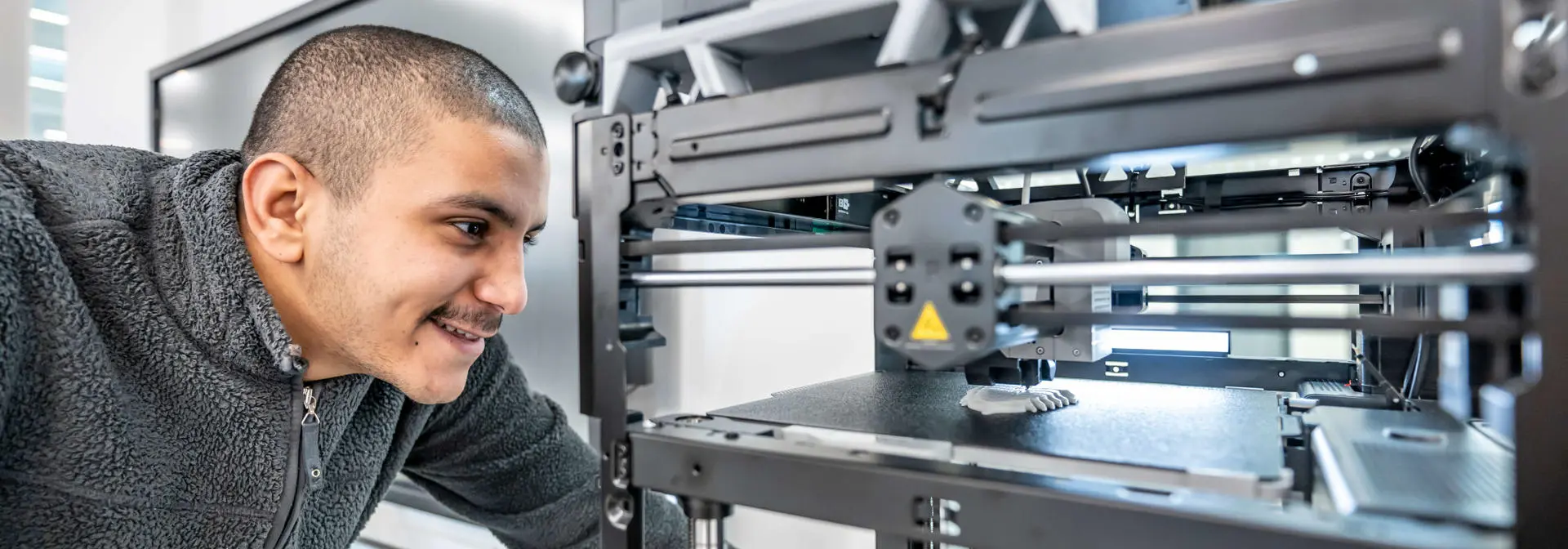 Mechanical Engineering student using a 3-D printer