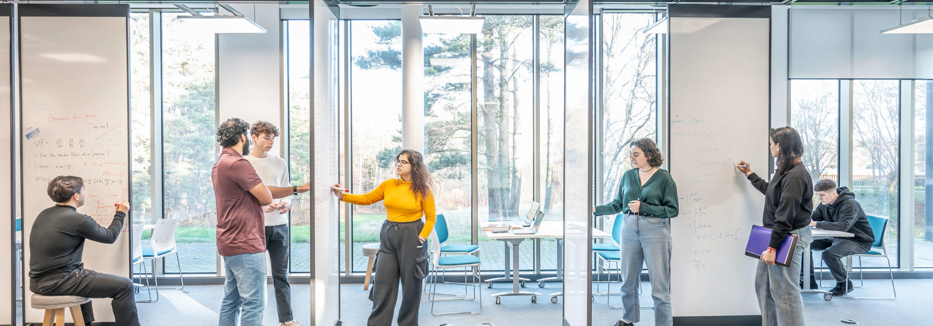 Students discussing ideas and collaborating in a contemporary study space.