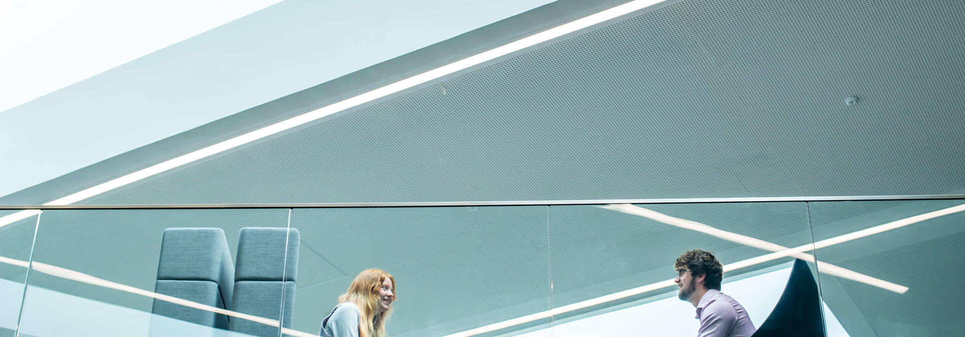 Two students seated in conversation on a mezzanine floor